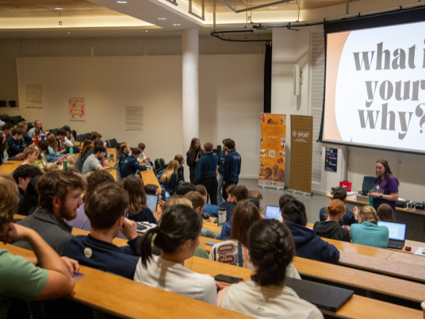 Group of students listening to a talk in a large lecture theatre.